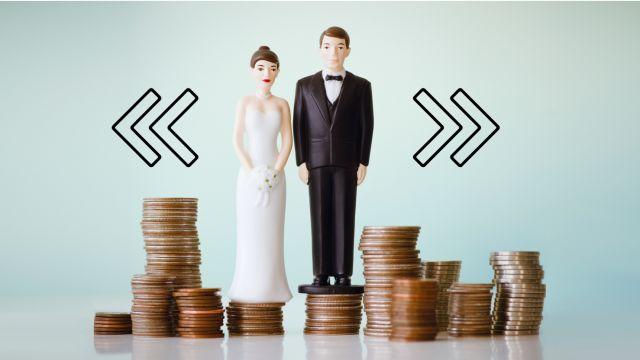 cake-topper couple stand on stacks of coins