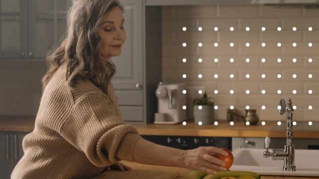 Silver haired woman sets fruit on counter