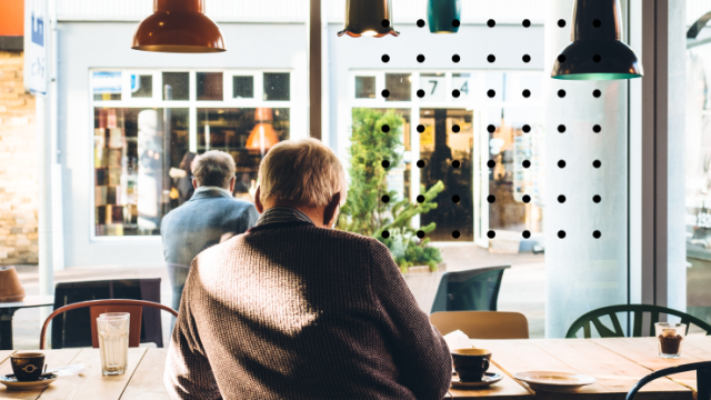 man sits at table outside