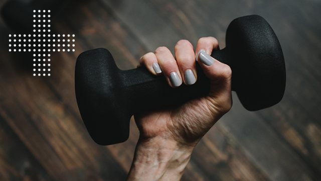 Manicured hand holding a small exercise weight